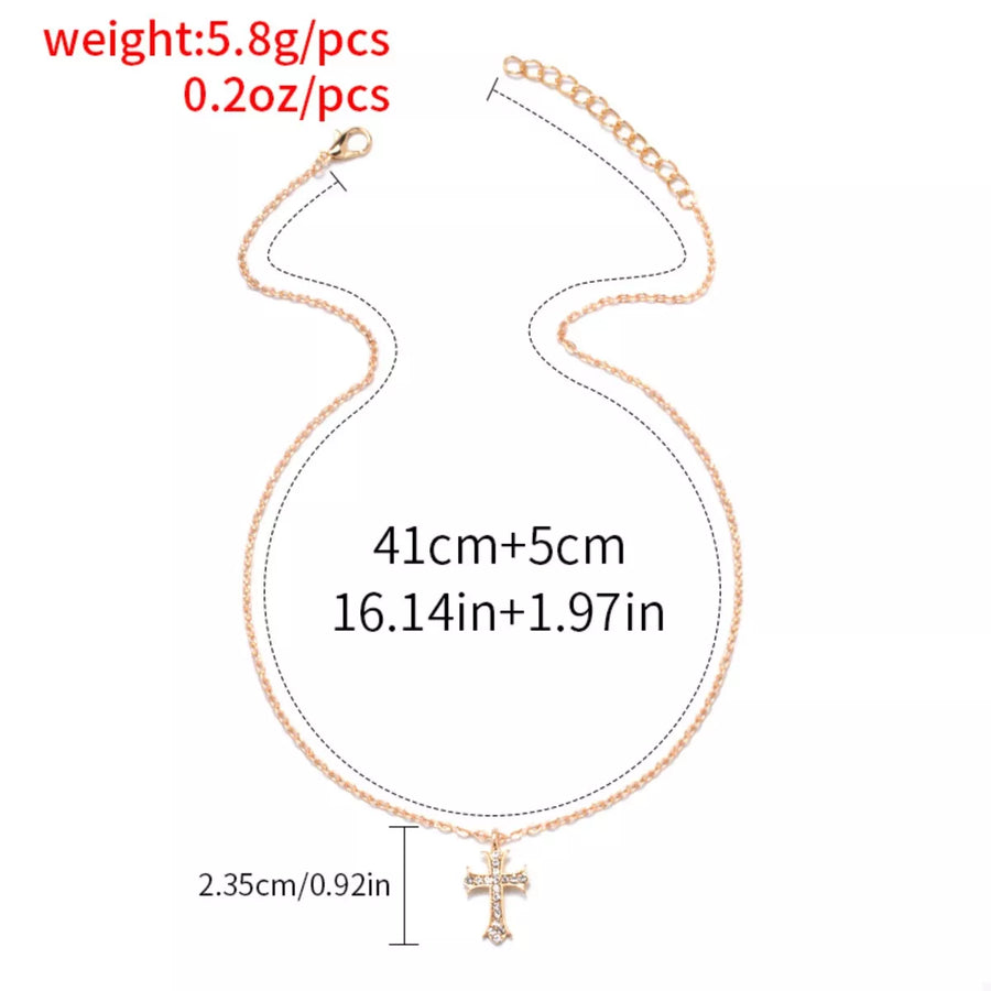Gold rhinestone cross pendant necklace with adjustable chain.