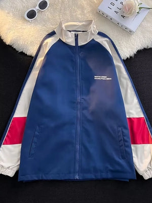 Men's blue zip-up track jacket with white and red colorblock sleeves and white collar.