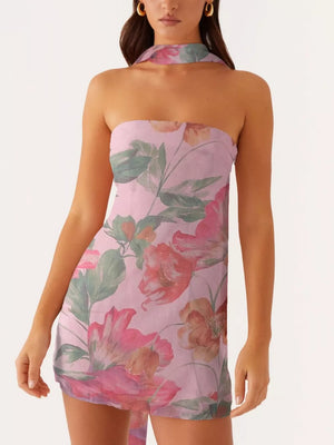 Strapless mini dress in blush pink with a large floral print and halter neck detail.