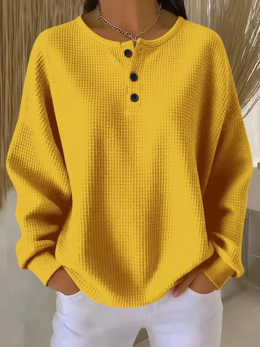 Yellow waffle knit top with button detail and crew neck.