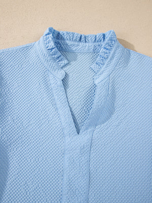 Light blue textured blouse with ruffled V-neck and collar