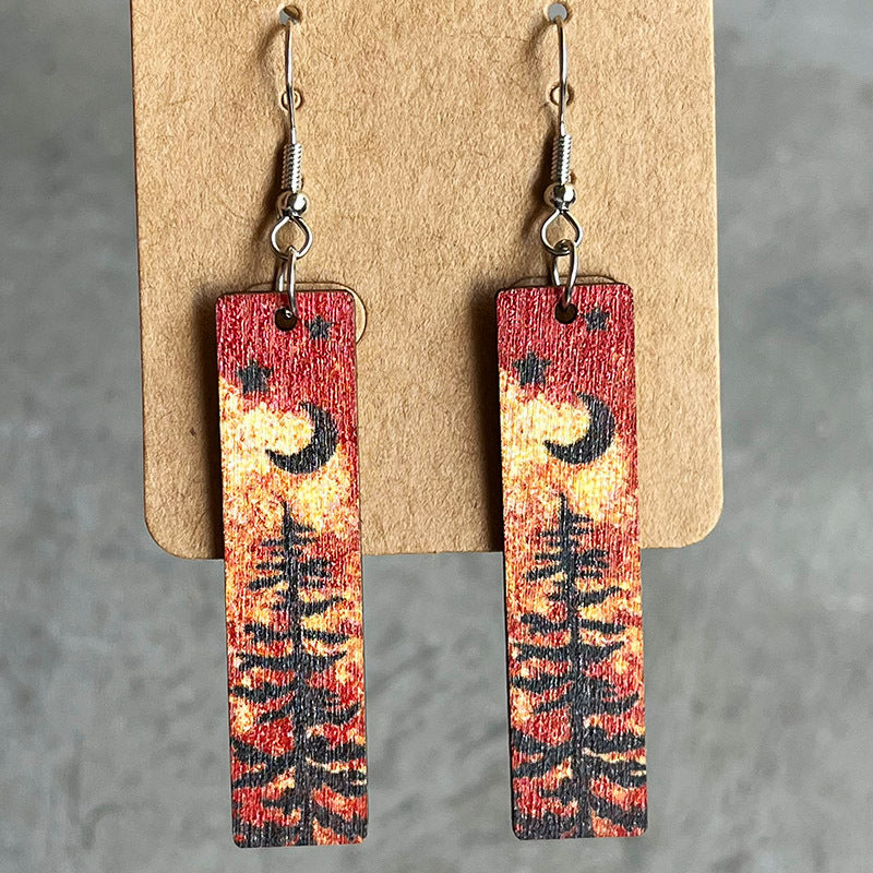 Painted landscape dangle earrings with moon and tree scene, red and yellow sunset colors.