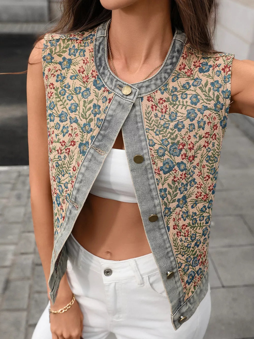 Floral tapestry denim vest with button-down front and round neckline.