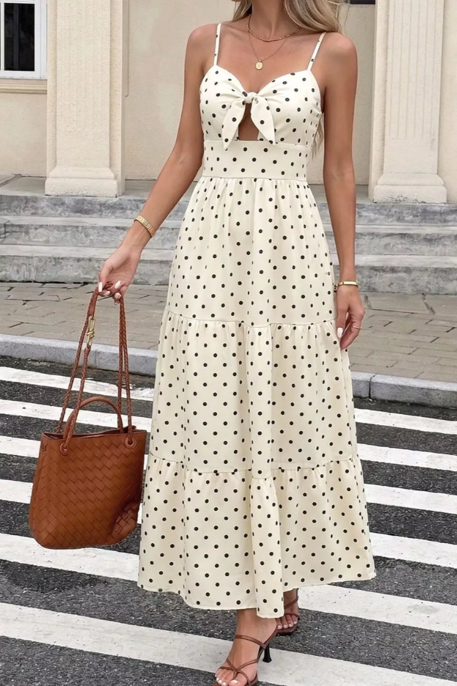 Cream polka dot maxi dress with cutout and bow detail, tiered skirt, spaghetti straps.