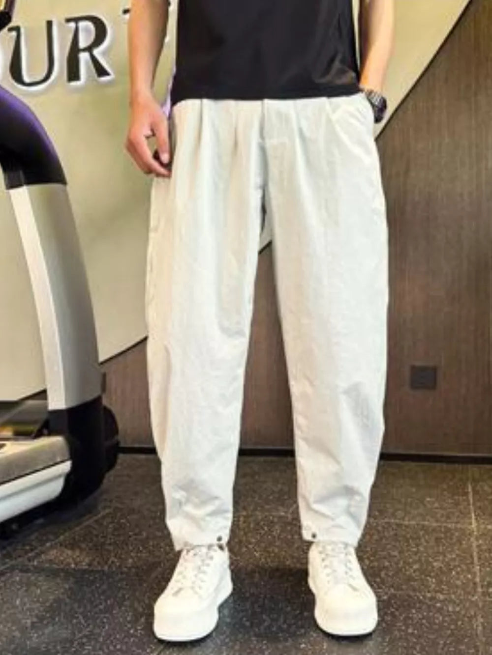 Light gray cargo pants with adjustable cuffs and pockets, worn by a person.