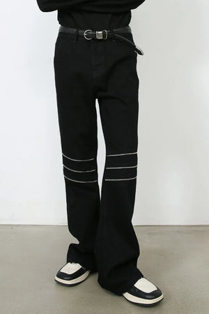 Black bootcut jeans with triple zipper detail at the knees.