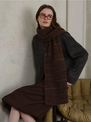 Textured mélange knit scarf in Chocolate, styled with a dark sweater and brown skirt.