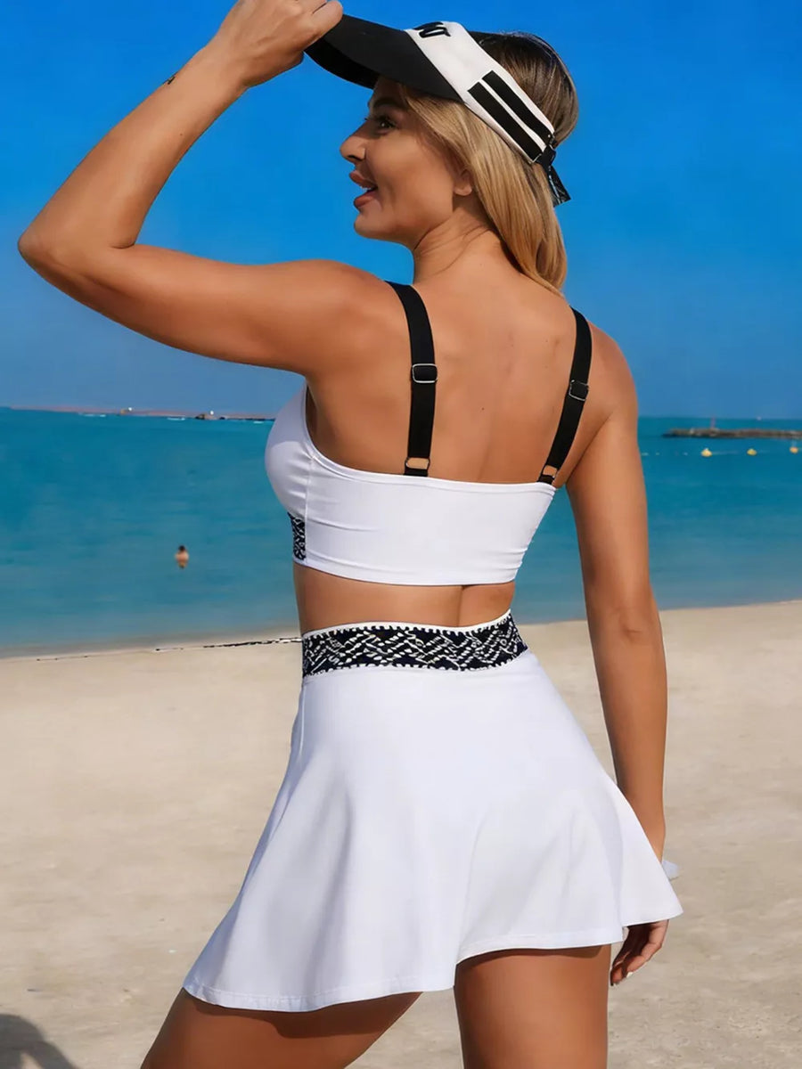 White tank top and skort set with black contrast trim and straps.