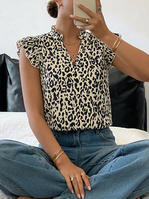 Leopard print top with ruffled cap sleeves and mock neck.