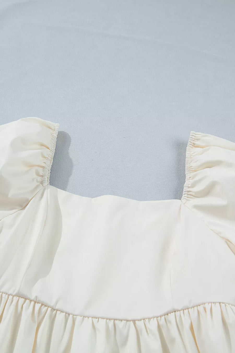 Cream puff sleeve dress with square neckline and ruffled hem detail.