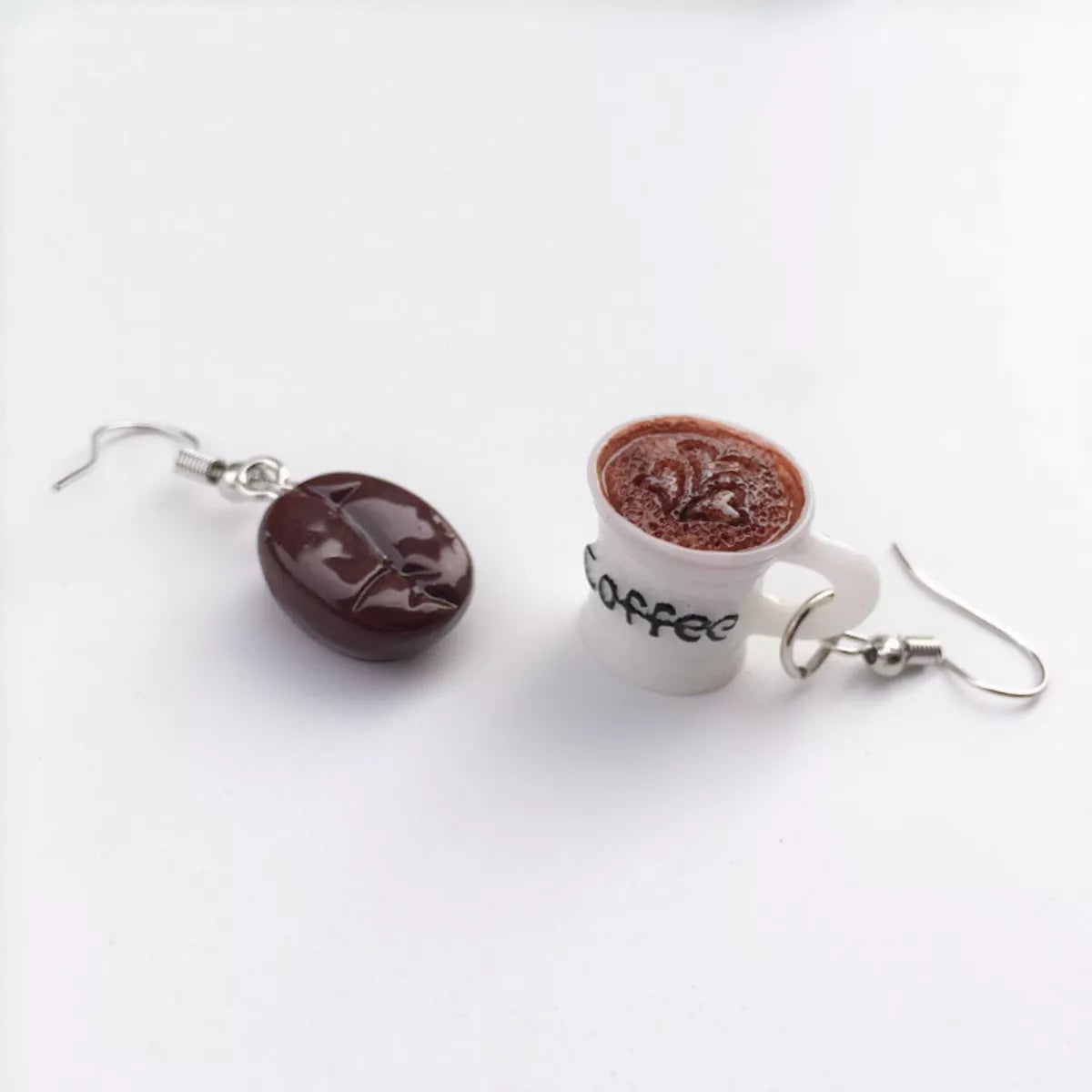 Coffee bean and cup drop earrings with coffee text detail.