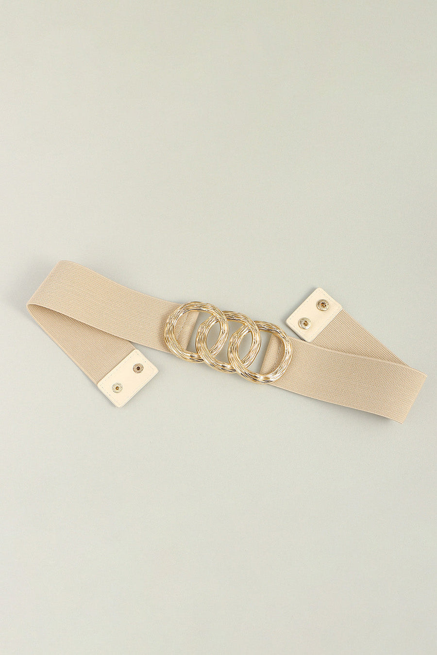 Tan elastic belt with triple gold interlocking ring buckle and snap closure.