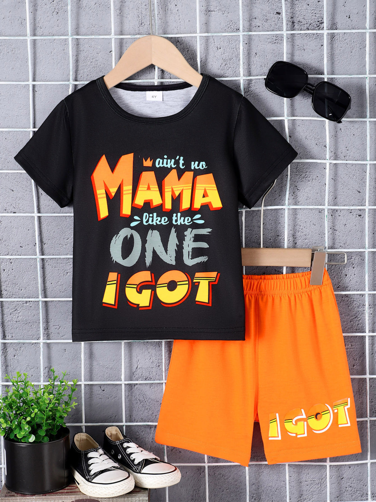 Black graphic tee with "Mama" text and orange shorts set for boys.