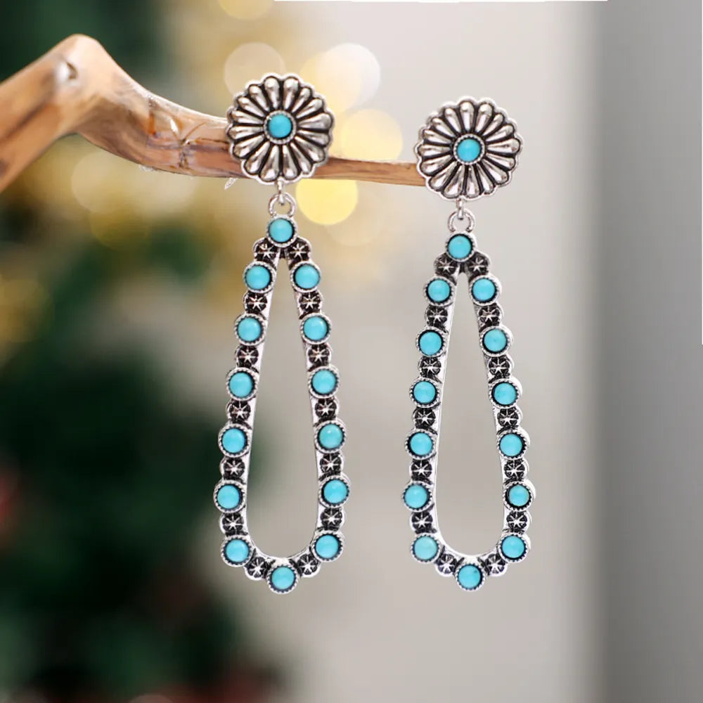 Silver floral turquoise bead drop earrings with a teardrop shape.