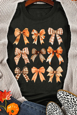 Black crewneck sweatshirt with a print of various autumn-themed bows in plaid and speckled patterns.