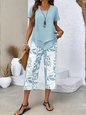 Light blue layered short sleeve top with blue and white leaf print cropped pants.