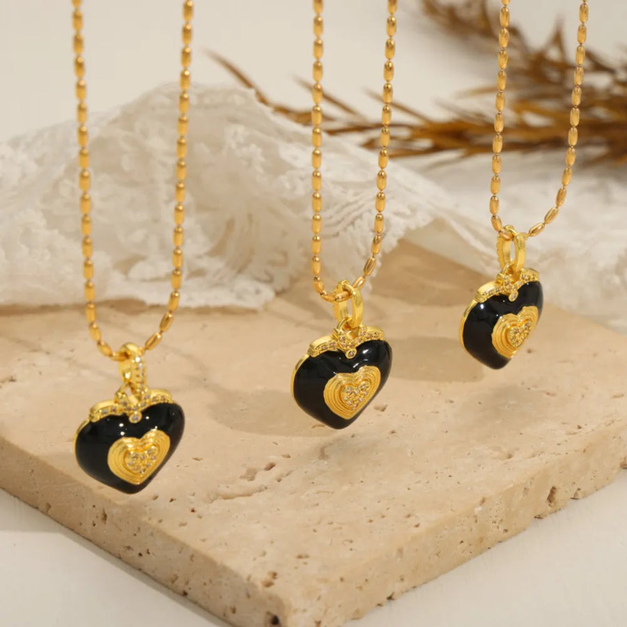 Gold necklace with black enamel heart pendant and diamond accents