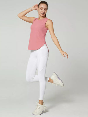 Pink sleeveless athletic tank top with curved hem and white leggings with pocket detail.