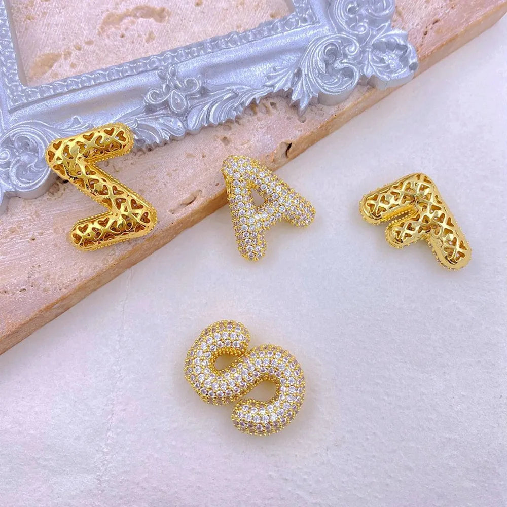 Puffed pave initial pendant necklace charms in gold, with clear stones on letters S and A.