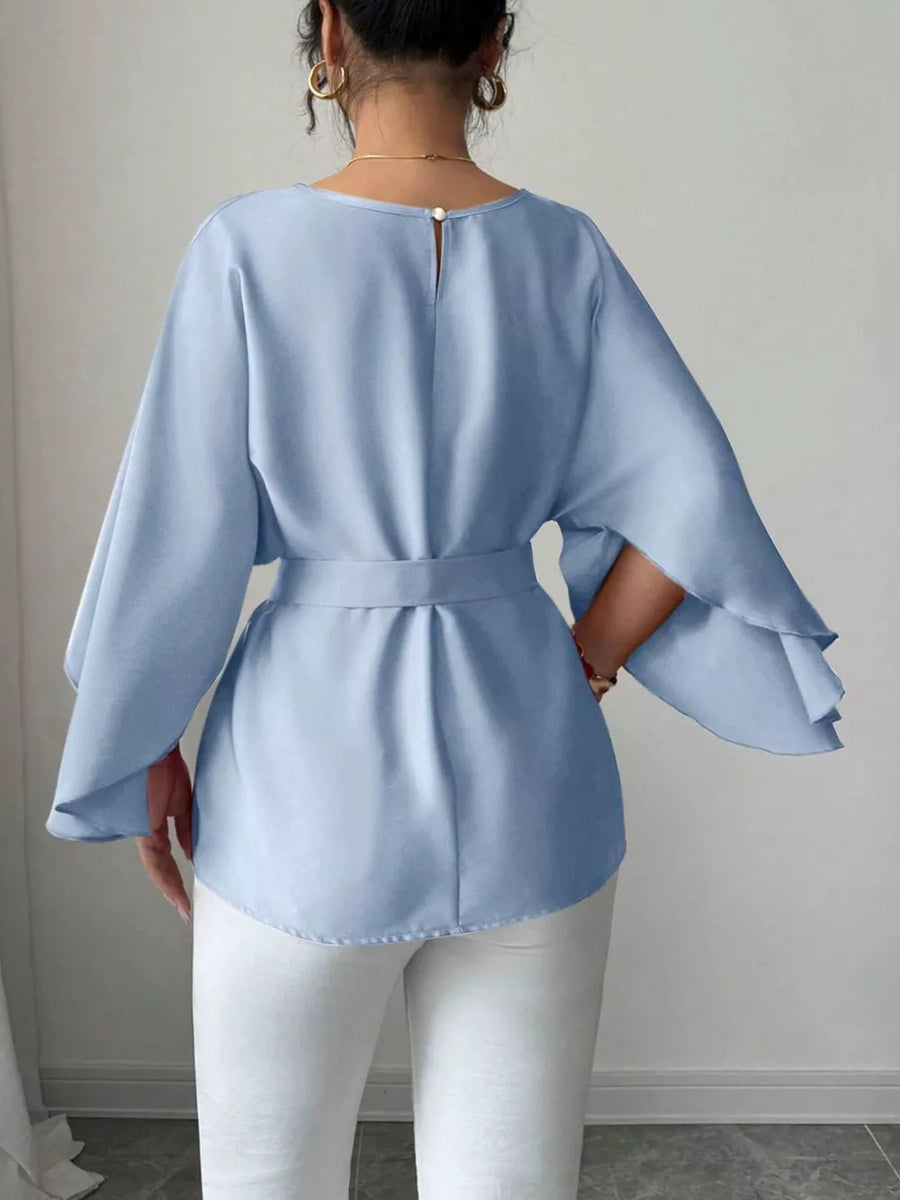 Light blue belted blouse with batwing sleeves and button back detail.