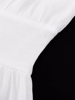 White crinkle fabric dress with gathered bodice and tiered skirt detail.