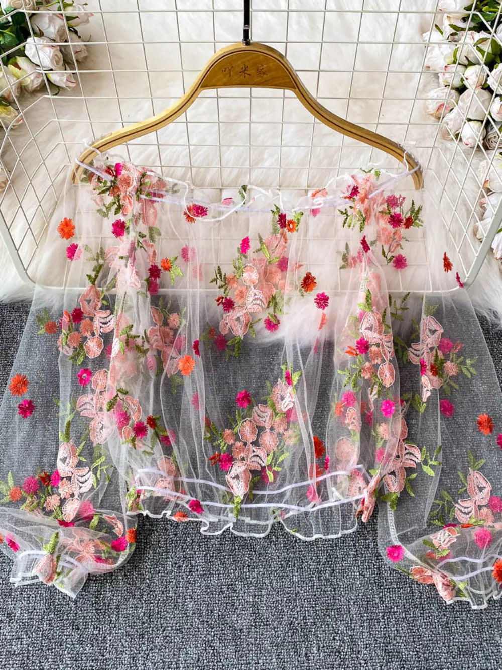White off-shoulder t-shirt with allover floral embroidery and sheer sleeves.