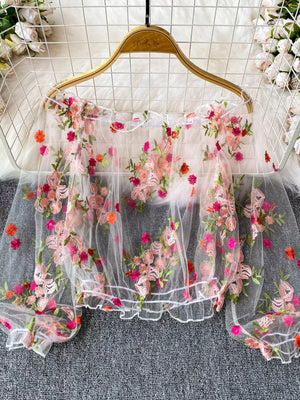 White off-shoulder t-shirt with allover floral embroidery and sheer sleeves.