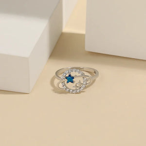 Silver ring with blue zircon star and orbiting stars, sterling silver band