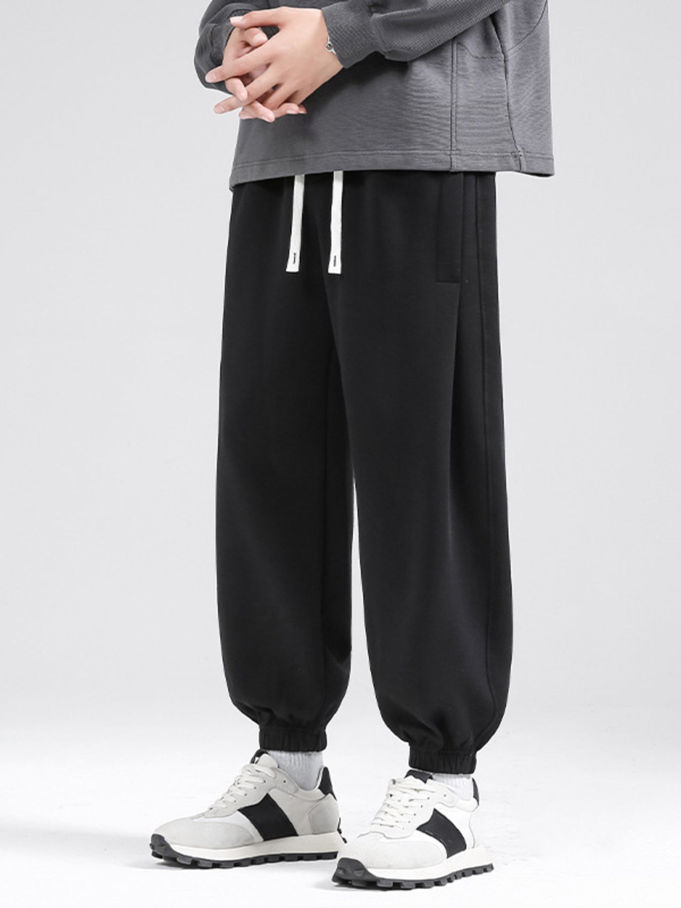 Black relaxed fit sweatpants with drawstring and cuffed ankles.