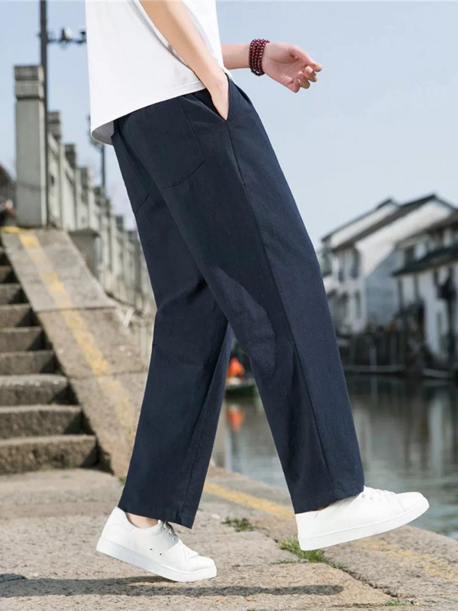 Men's navy blue sweatpants with drawstring and pockets, styled with a white t-shirt.