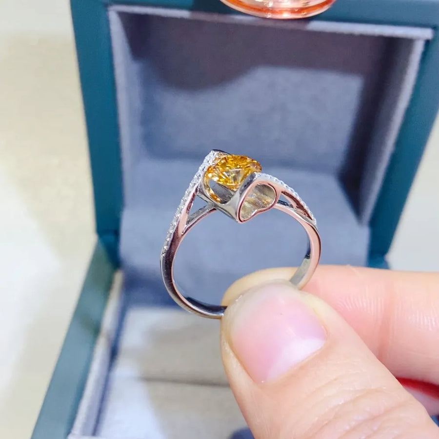 Radiant yellow moissanite twist ring with pave diamond accents in silver.