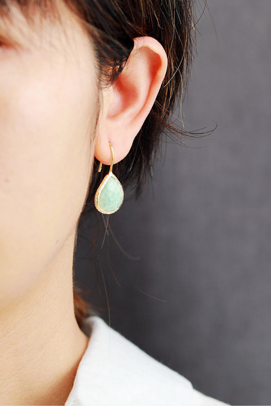 Textured gemstone drop earrings in aqua with gold trim and hook closure.