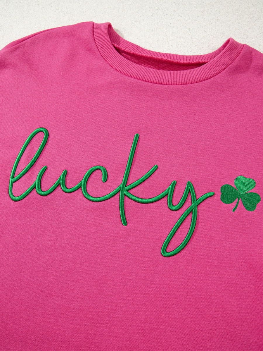 Pink crew neck sweatshirt with green embroidered lucky clover graphic