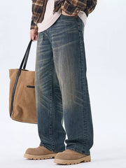 Men's relaxed fit wide-leg jeans in washed blue denim with a faded look.