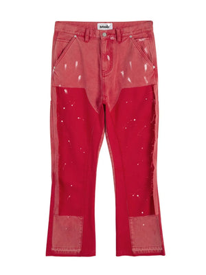 Split panel bootcut jeans in red with paint splatter detail and distressed patches.