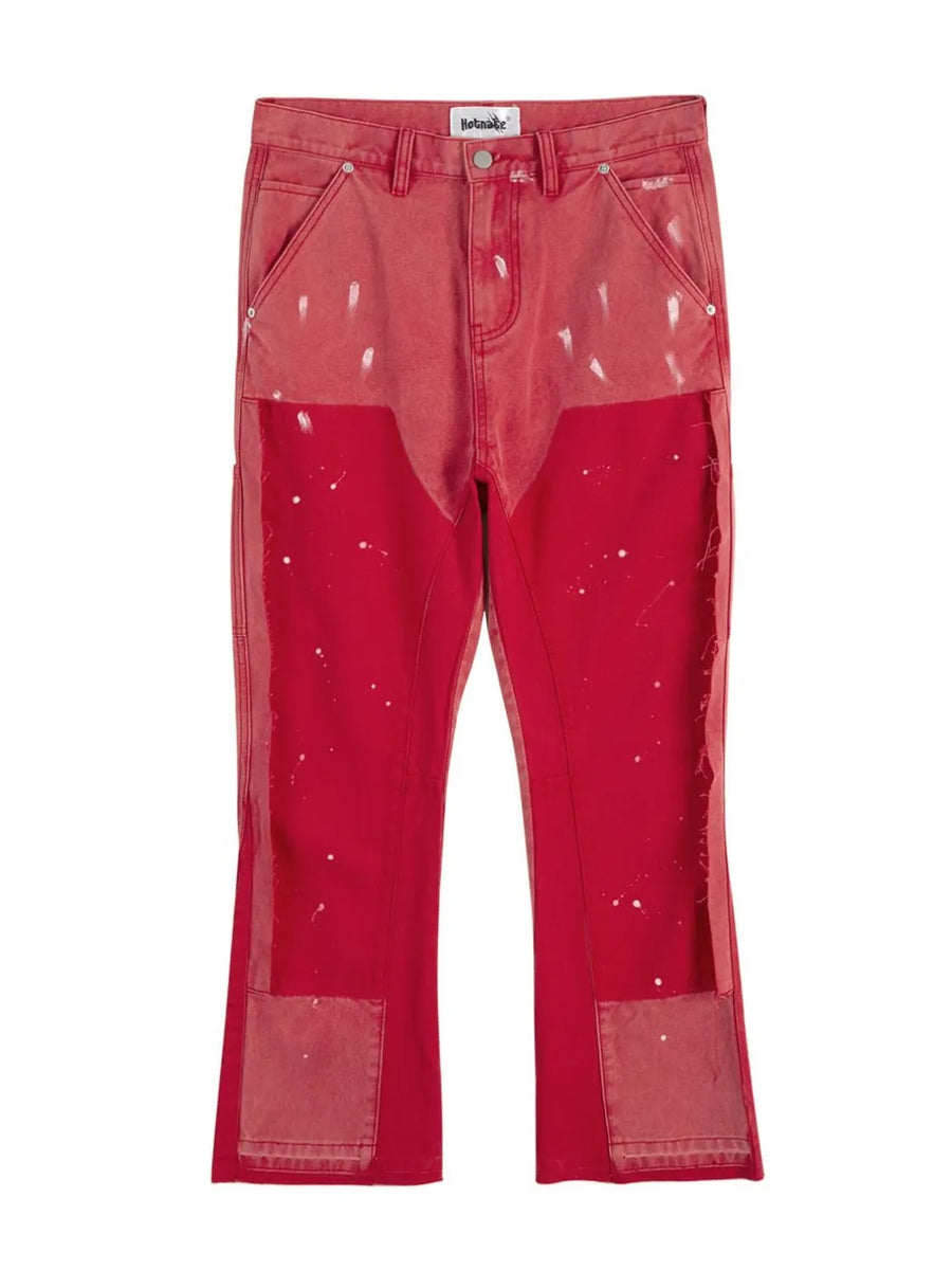 Split panel bootcut jeans in red with paint splatter detail and distressed patches.