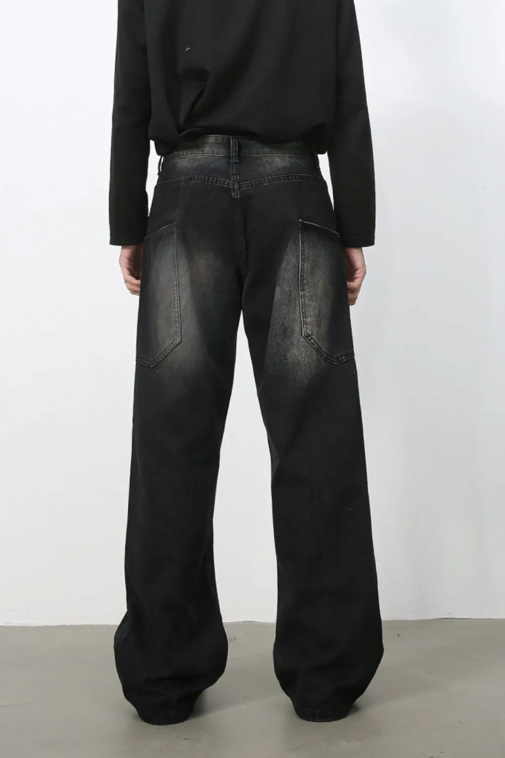 Faded wash wide leg denim jeans in dark with a relaxed fit and visible pocket details.