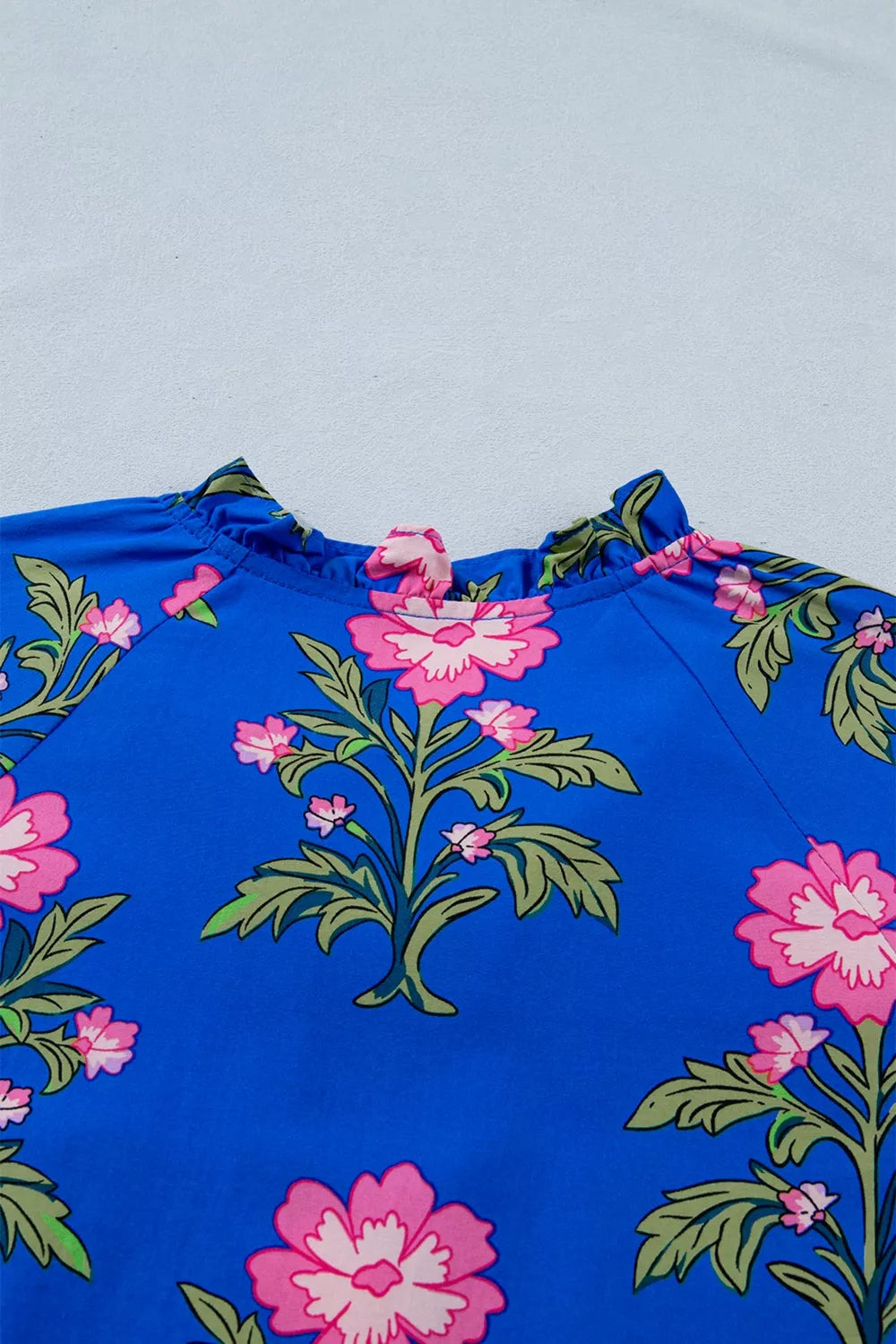 Blue cotton dress with pink floral print and ruffled neckline.