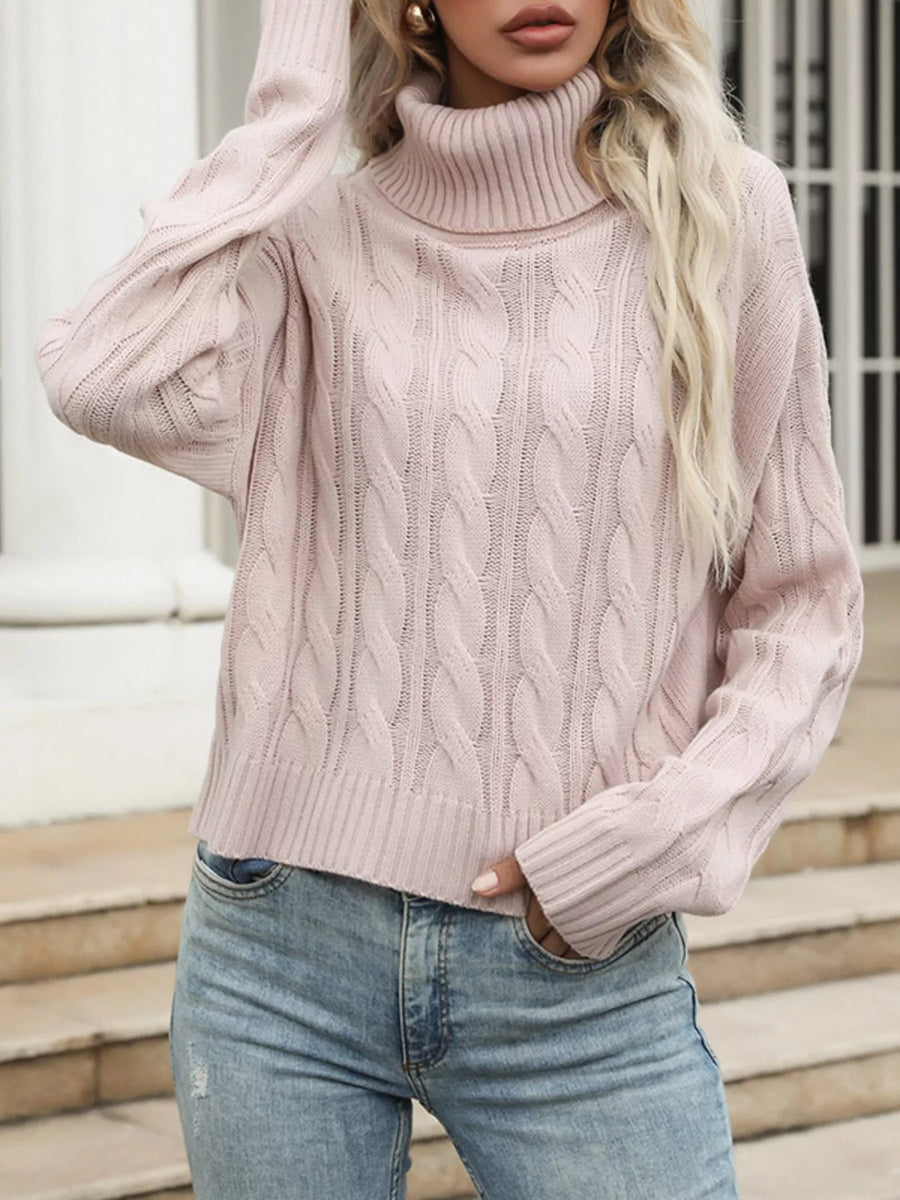 Pink cable knit turtleneck sweater with a cozy, casual style.