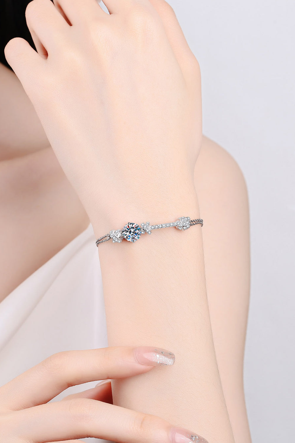 Silver bracelet with sparkling charms and a central blue crystal cluster.