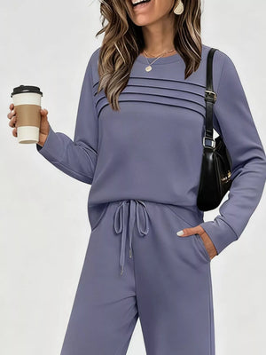 Dusty blue casual long-sleeve top and pants set with drawstring waist and pleated detail on top.