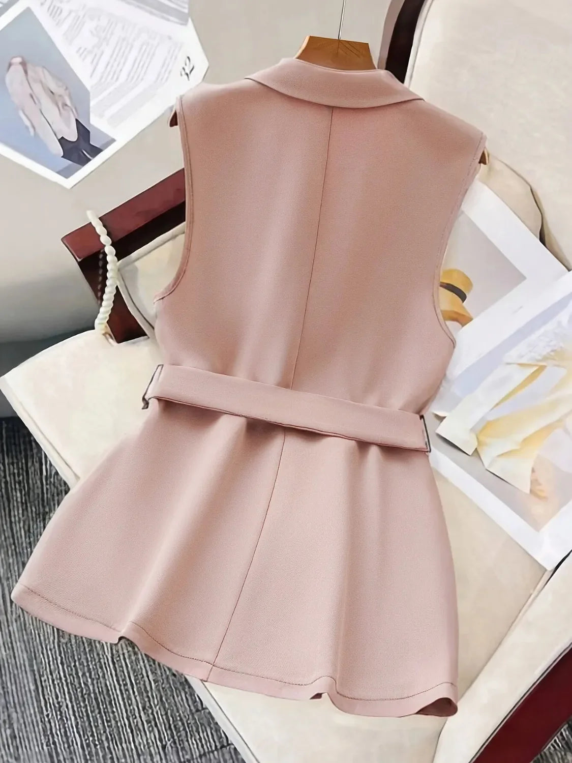 Sleeveless blush blazer vest with a matching waist-defining belt and peplum hem.
