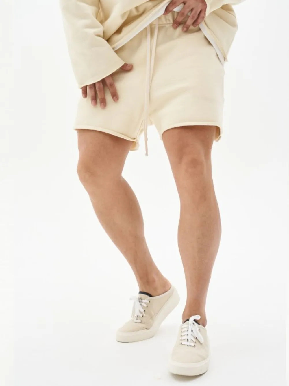 Beige fleece lounge shorts with raw hem and drawstring waist