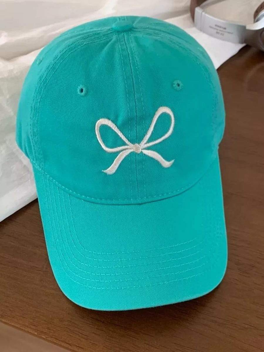 Teal baseball cap with white embroidered bow detail