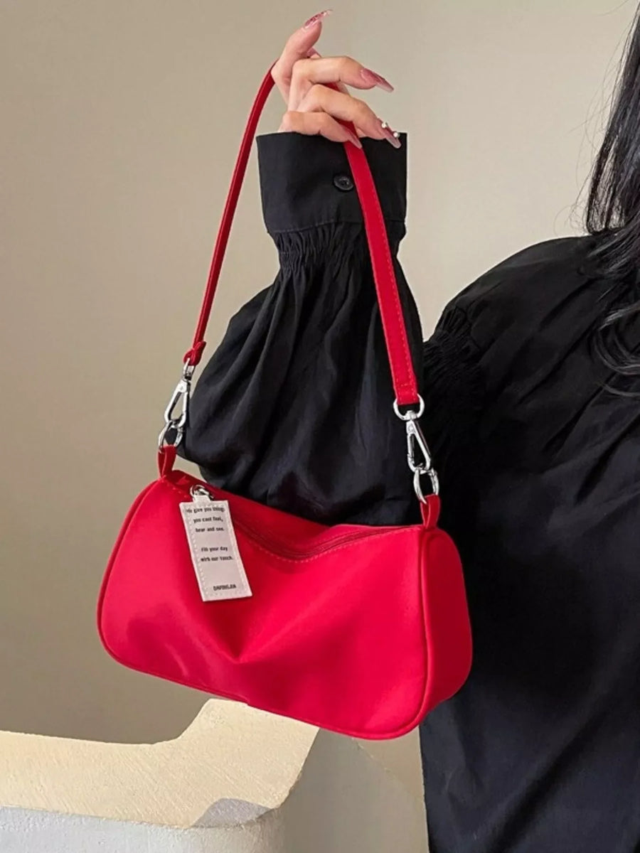 Red nylon mini crossbody bag with a white tag and silver hardware.