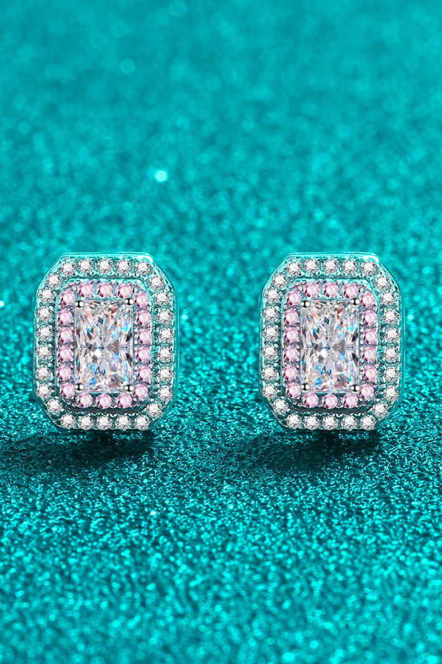 Silver halo stud earrings with emerald-cut center stone and pink accent stones.