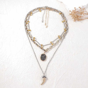 silver necklace featuring layered and geometric