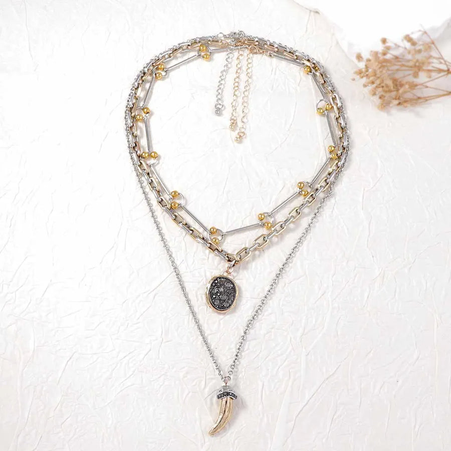 silver necklace featuring layered and geometric