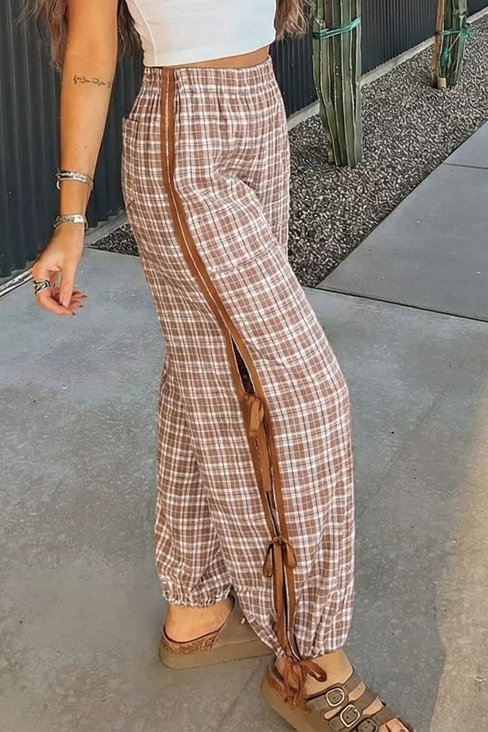 Plaid drawstring pants with brown side ties and elastic cuffs.