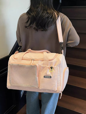 Pink duffel bag with mesh pocket and zippered compartments, adjustable strap.